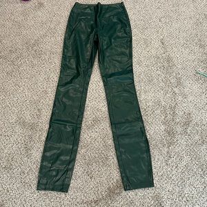 Dark green pleather pants. There are two slits. One on each end by the ankle.
